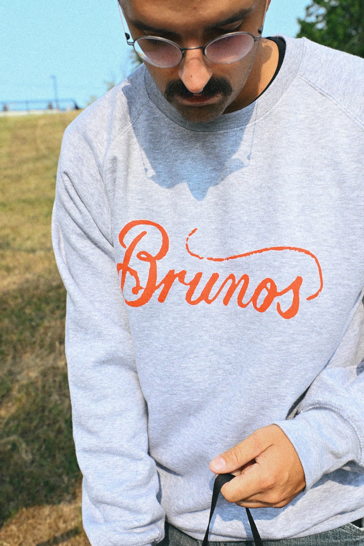 Grey crewneck with Brunos in red script across the chest